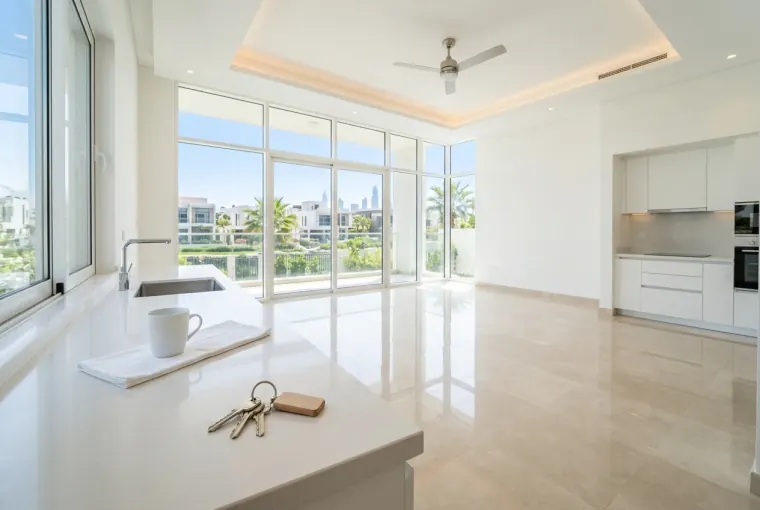 A closed-up Dubai villa living room with curtains drawn, empty while the family travels for the summer