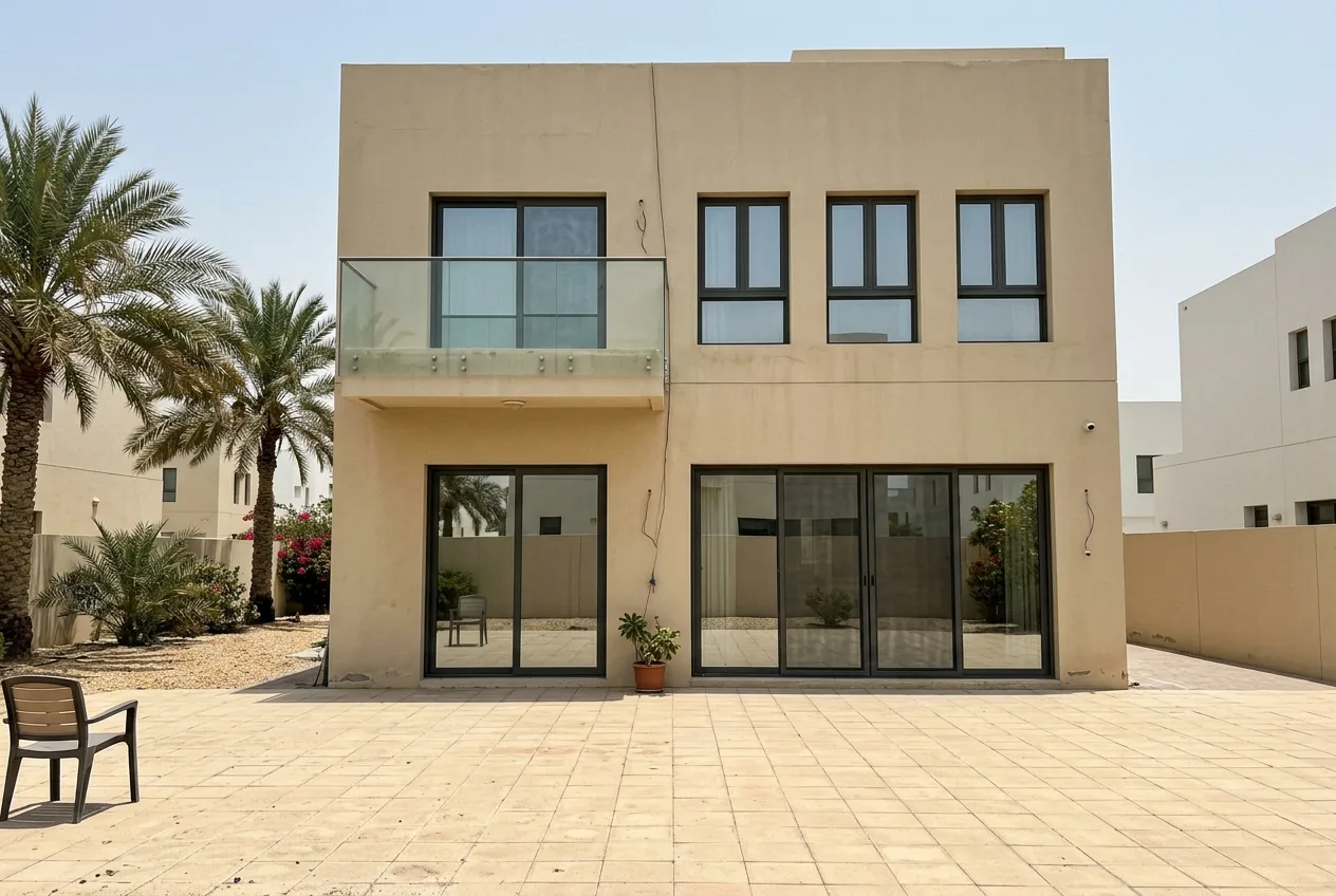 The rear of a two-storey Dubai villa with large sliding glass doors, upstairs windows and a glass balcony, all freshly cleaned